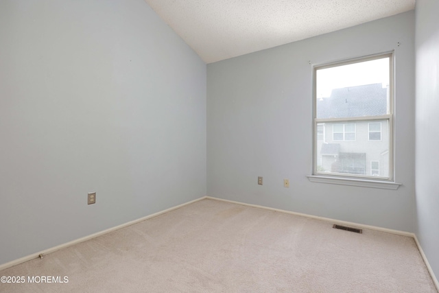 62 Cohasset Ct, Holmdel, NJ 07733 - empty room featuring carpet flooring, baseboards, vaulted ceiling, and a textured ceiling