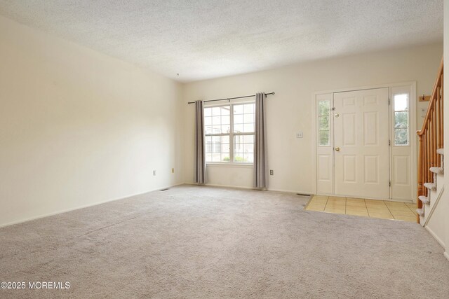 62 Cohasset Ct, Holmdel, NJ 07733 - carpeted foyer featuring stairs, a textured ceiling, and tile patterned flooring