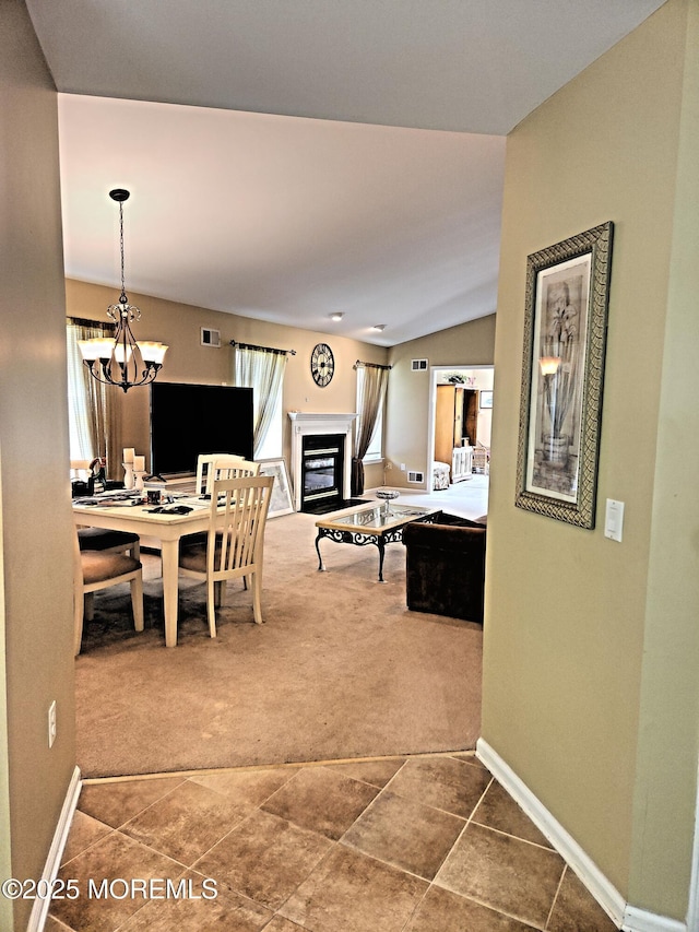 12 Skylark Ln, Lakewood, NJ 08701 - carpeted dining space with a glass covered fireplace, baseboards, a chandelier, vaulted ceiling, and tile patterned flooring
