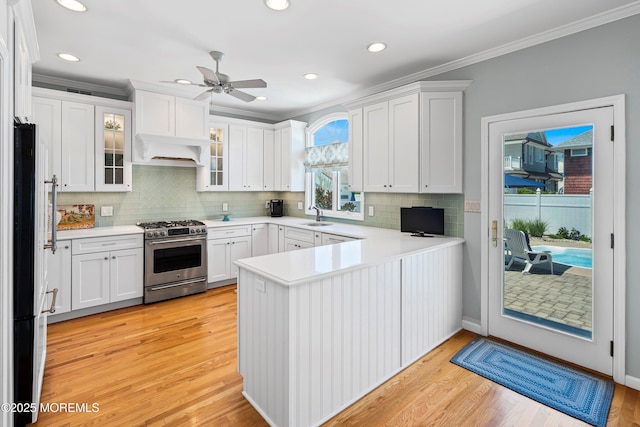7 Brown Ave, Lavallette, NJ 08735 - kitchen with stainless steel stove, a peninsula, a sink, ornamental molding, and freestanding refrigerator