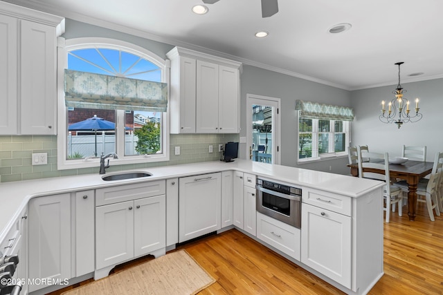 7 Brown Ave, Lavallette, NJ 08735 - kitchen with a sink, healthy amount of natural light, stainless steel oven, a peninsula, and crown molding