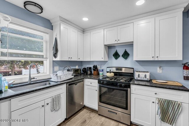 1208 Pine Tree Way, Belmar, NJ 07719 - kitchen with stainless steel appliances, a sink, white cabinets, light wood-style floors, and dark stone counters