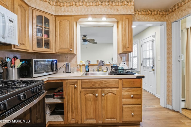 1920 W Lake Ave, Neptune Township, NJ 07753 - kitchen featuring white microwave, gas range, ceiling fan, light countertops, and glass insert cabinets