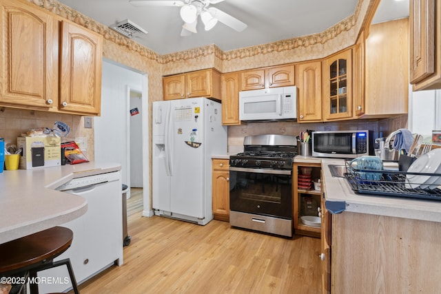 1920 W Lake Ave, Neptune Township, NJ 07753 - kitchen featuring stainless steel appliances, ceiling fan, backsplash, light countertops, and glass insert cabinets
