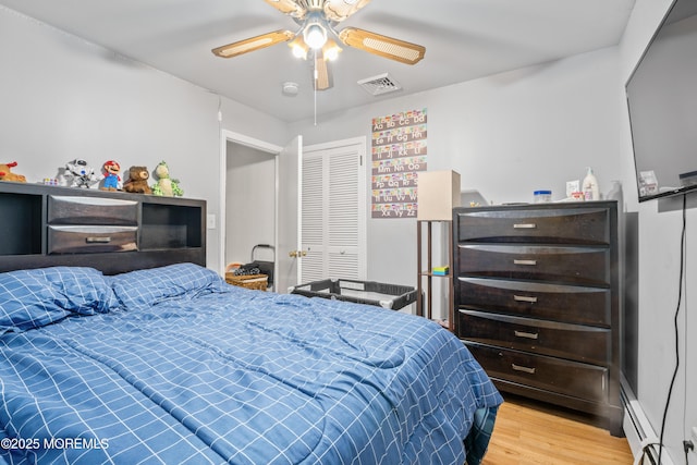 1920 W Lake Ave, Neptune Township, NJ 07753 - bedroom featuring light wood-style floors, a baseboard heating unit, a closet, and a ceiling fan