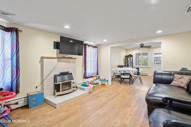 1920 W Lake Ave, Neptune Township, NJ 07753 - living area with a wood stove, wood finished floors, a ceiling fan, recessed lighting, and a baseboard radiator
