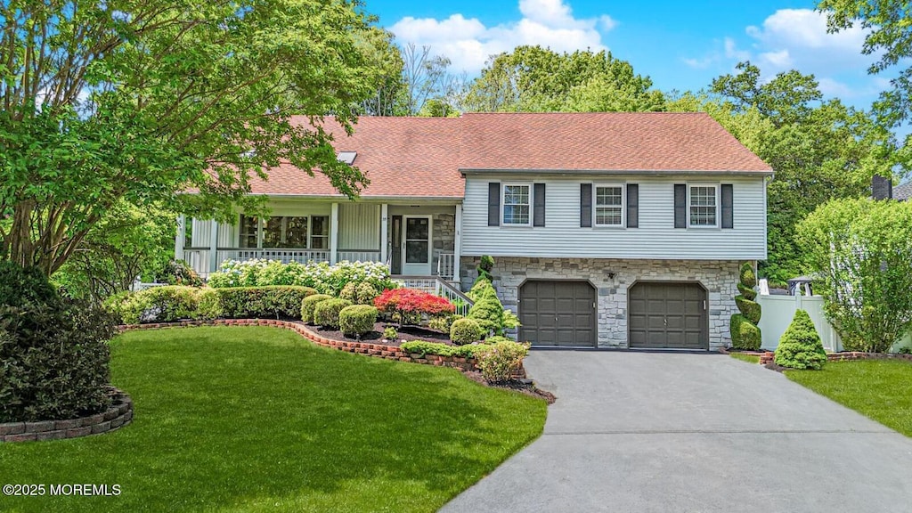 35 High Ridge Rd, Ocean Twp, NJ 07712 - split level home featuring stone siding, driveway, an attached garage, and a front yard