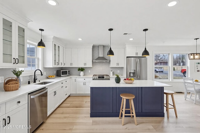 559 Holmdel Rd, Hazlet, NJ 07730 - kitchen featuring appliances with stainless steel finishes, wall chimney range hood, a kitchen island, a kitchen breakfast bar, and decorative backsplash