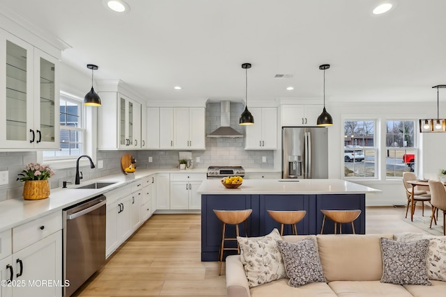559 Holmdel Rd, Hazlet, NJ 07730 - kitchen with stainless steel appliances, wall chimney range hood, a sink, a center island, and light wood-type flooring