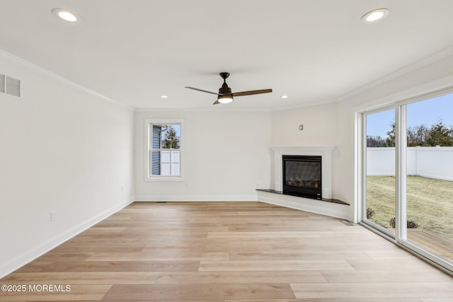 559 Holmdel Rd, Hazlet, NJ 07730 - unfurnished living room with healthy amount of natural light, crown molding, a glass covered fireplace, light wood-type flooring, and a ceiling fan