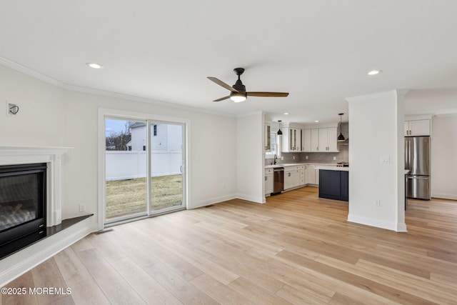 559 Holmdel Rd, Hazlet, NJ 07730 - unfurnished living room with ornamental molding, a ceiling fan, recessed lighting, light wood-style flooring, and a glass covered fireplace