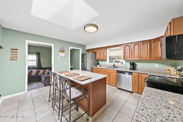 1 Bough Ct, Toms River, NJ 08753 - kitchen featuring appliances with stainless steel finishes, a sink, a breakfast bar, light tile patterned floors, and brown cabinets
