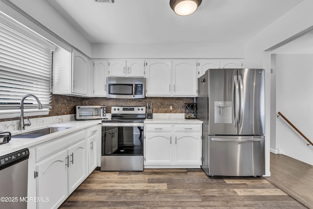 711 Chelsea St, Forked River, NJ 08731 - kitchen with stainless steel appliances, a sink, white cabinets, and wood finished floors