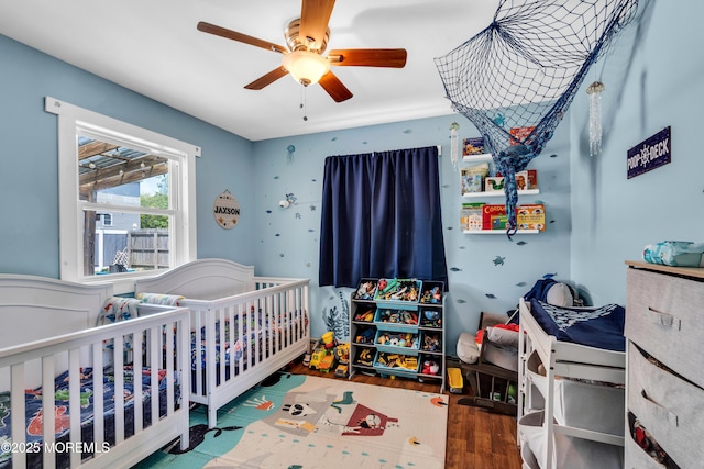 1004 Pensacola Rd, Forked River, NJ 08731 - bedroom with a crib, wood finished floors, and a ceiling fan