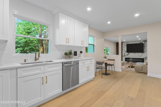 5 Rose St, Lincroft, NJ 07738 - kitchen with stainless steel dishwasher, a sink, a high end fireplace, light wood-style flooring, and light countertops