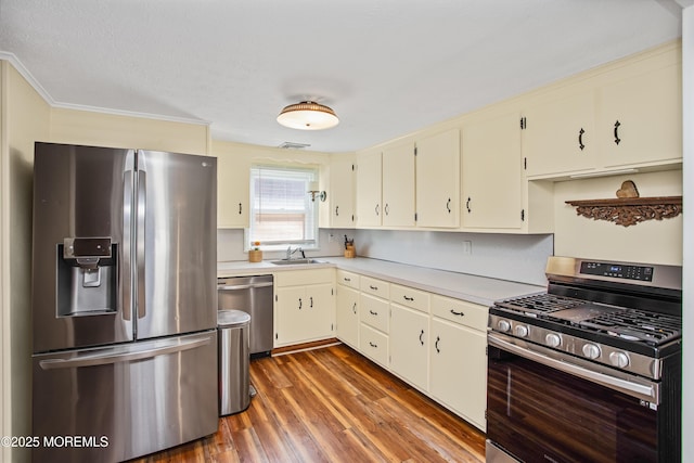 81 Curtis Pl, Manasquan, NJ 08736 - kitchen featuring stainless steel appliances, wood finished floors, light countertops, a sink, and crown molding