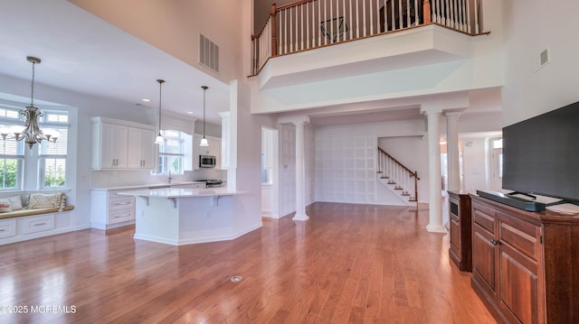 38 Ocean Grove Ln, Waretown, NJ 08758 - kitchen with appliances with stainless steel finishes, light countertops, a breakfast bar, light wood-style flooring, and a towering ceiling