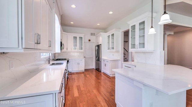 38 Ocean Grove Ln, Waretown, NJ 08758 - kitchen with appliances with stainless steel finishes, a sink, light wood finished floors, tasteful backsplash, and a peninsula