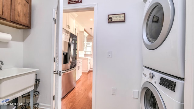 38 Ocean Grove Ln, Waretown, NJ 08758 - laundry area with estacked washer and dryer, light wood-style floors, cabinet space, and baseboards