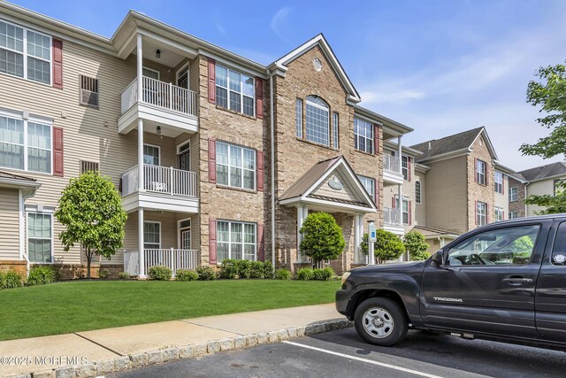 113 Sophee Ln, Lakewood, NJ 08701 - view of front of house featuring uncovered parking, a front lawn, and brick siding