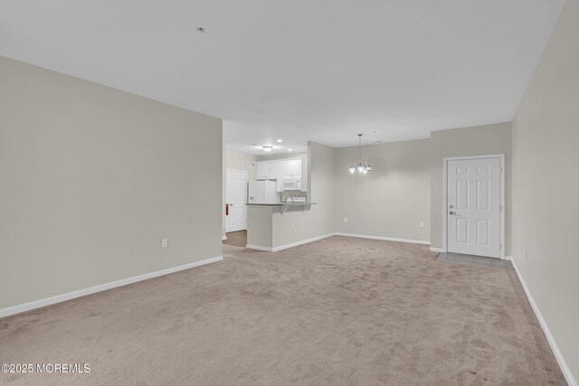 113 Sophee Ln, Lakewood, NJ 08701 - unfurnished living room with light carpet, a chandelier, and baseboards