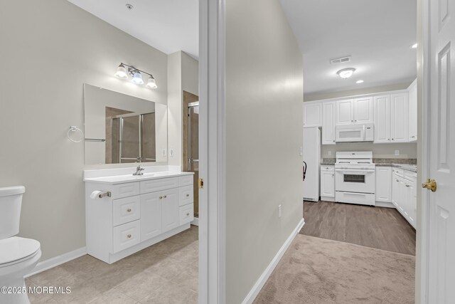 113 Sophee Ln, Lakewood, NJ 08701 - kitchen with white appliances, white cabinetry, baseboards, light countertops, and a sink