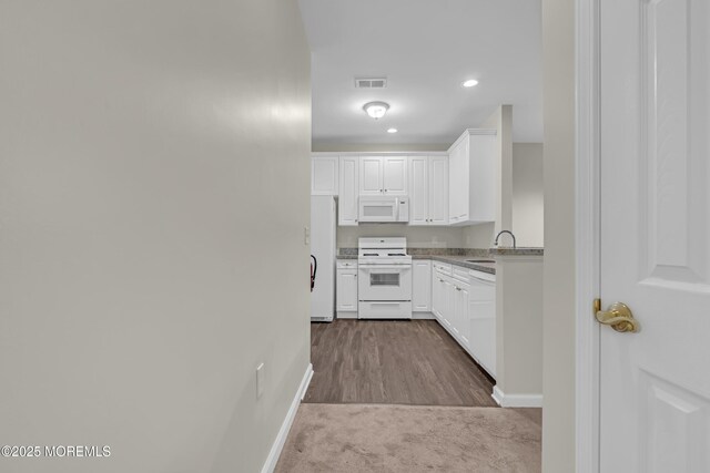 113 Sophee Ln, Lakewood, NJ 08701 - kitchen with white appliances, baseboards, white cabinets, a sink, and recessed lighting