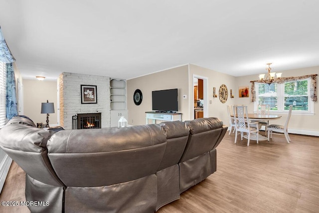 7 E Parkway Pl, Holmdel, NJ 07733 - living room with wood finished floors, a chandelier, built in shelves, a stone fireplace, and baseboards