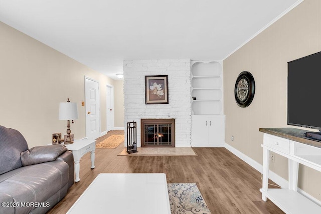 7 E Parkway Pl, Holmdel, NJ 07733 - living area featuring baseboards, wood finished floors, built in shelves, and a large fireplace