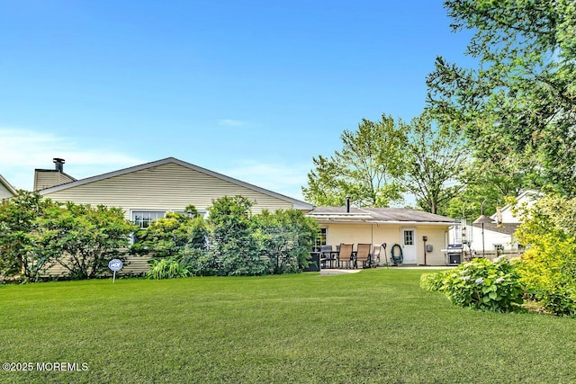 153 Lloyd Rd, Matawan, NJ 07747 - back of property with a lawn, a patio, and a chimney