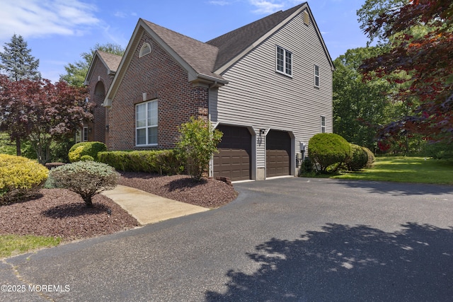 23 Emma Ln, Jackson, NJ 08527 - view of home's exterior featuring a garage, driveway, roof with shingles, and brick siding