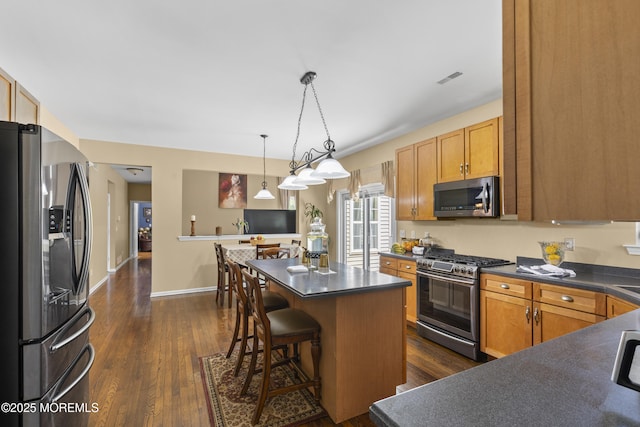 23 Emma Ln, Jackson, NJ 08527 - kitchen with stainless steel appliances, dark countertops, a breakfast bar area, and dark wood-style flooring