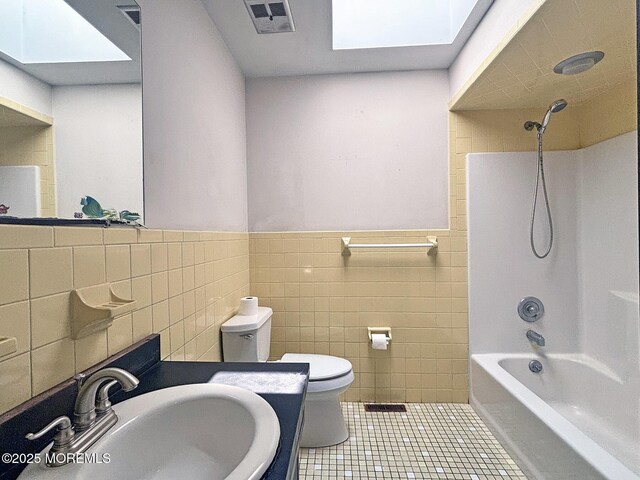 1124 Skiff Way Dr, Forked River, NJ 08731 - bathroom featuring a sink, a skylight, tile walls, toilet, and tile patterned floors