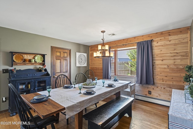 1172 Laurel Dr, Toms River, NJ 08753 - dining space with a baseboard heating unit, a chandelier, light wood-style floors, and wooden walls