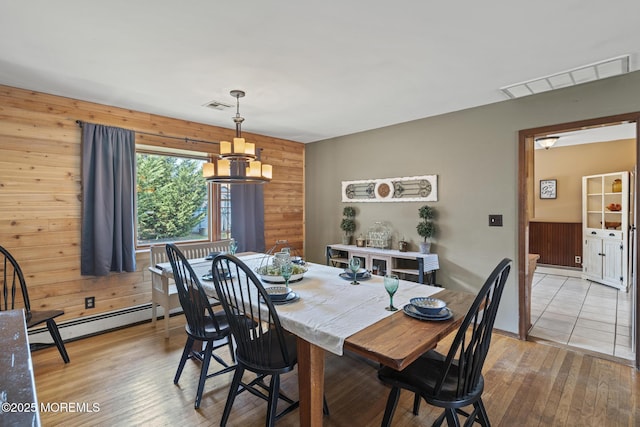 1172 Laurel Dr, Toms River, NJ 08753 - dining room featuring a baseboard heating unit, wooden walls, and light wood-style flooring
