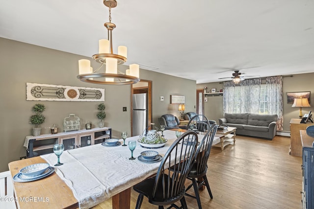 1172 Laurel Dr, Toms River, NJ 08753 - dining room with baseboard heating, a chandelier, a ceiling fan, and wood finished floors