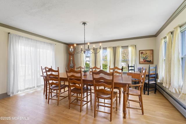 96 Gordons Corner Rd, Manalapan, NJ 07726 - dining space with crown molding, baseboard heating, healthy amount of natural light, light wood-style floors, and a textured ceiling