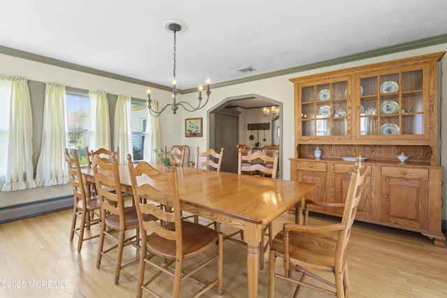 96 Gordons Corner Rd, Manalapan, NJ 07726 - dining room with a chandelier, arched walkways, crown molding, a baseboard heating unit, and light wood-type flooring