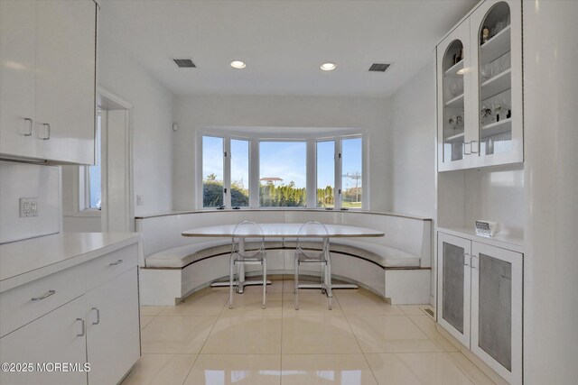 58 Ocean Ave, Deal, NJ 07723 - kitchen with white cabinetry, light countertops, glass insert cabinets, light tile patterned floors, and recessed lighting