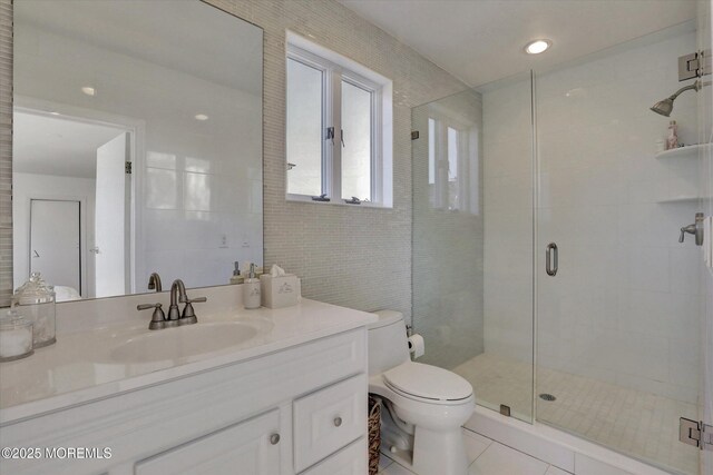 58 Ocean Ave, Deal, NJ 07723 - bathroom with tile patterned floors, a shower stall, vanity, toilet, and tile walls