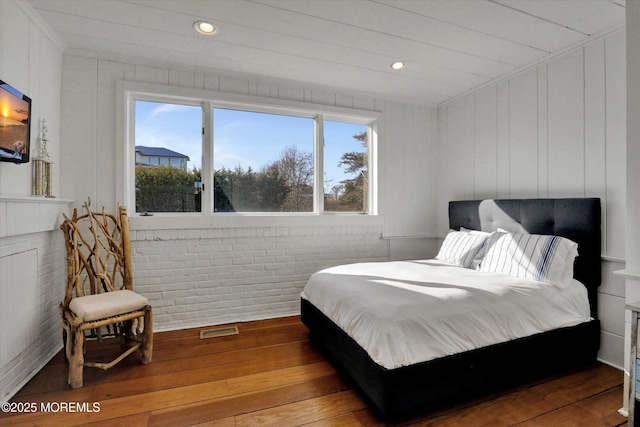 58 Ocean Ave, Deal, NJ 07723 - bedroom with wood-type flooring, brick wall, recessed lighting, and a decorative wall