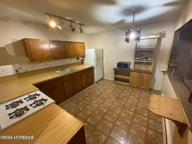 10 Hemlock St Unit D, Toms River, NJ 08757 - kitchen with freestanding refrigerator, stainless steel microwave, tile walls, a sink, and tile patterned floors