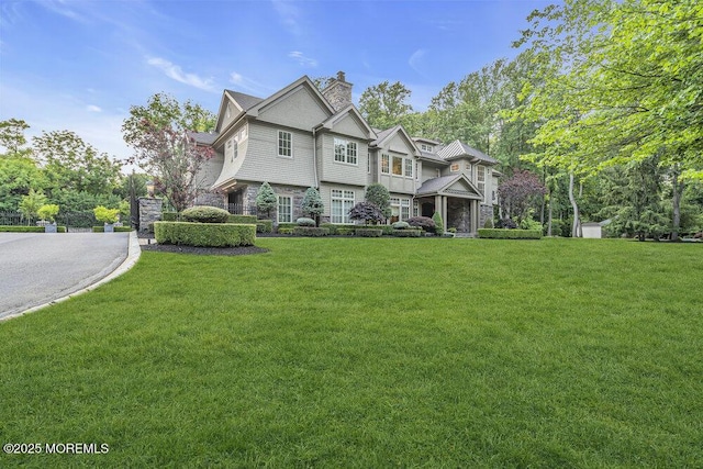 23 Pilgrim Way, Colts Neck, NJ 07722 - view of front facade with stone siding, a front yard, and a chimney