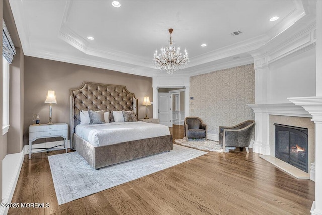 23 Pilgrim Way, Colts Neck, NJ 07722 - bedroom with a chandelier, wood finished floors, crown molding, a lit fireplace, and a tray ceiling