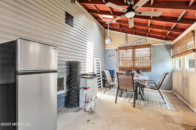 164 Holly St, Port Reading, NJ 07064 - dining room featuring vaulted ceiling, unfinished concrete flooring, a ceiling fan, and wooden walls