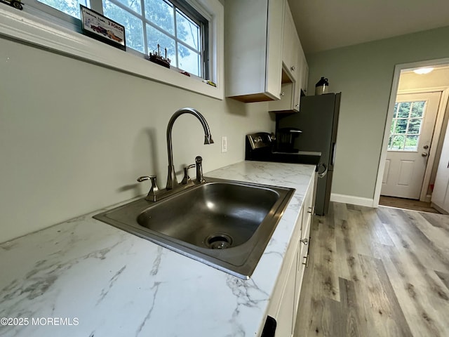 470 Mantoloking Rd, Brick, NJ 08723 - kitchen with a sink, white cabinets, light stone countertops, light wood finished floors, and freestanding refrigerator