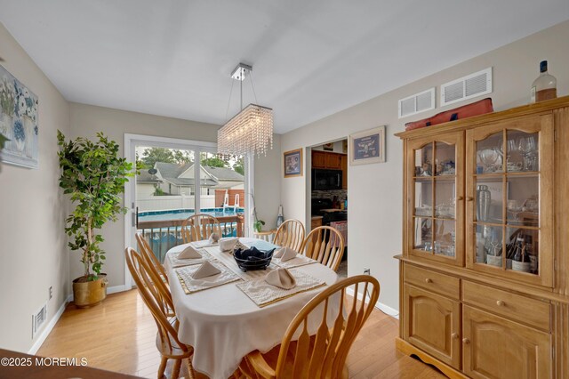 40 Wood St, Keansburg, NJ 07734 - dining area with a chandelier, light wood-style flooring, and baseboards