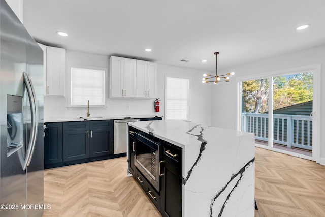 118 Cedar Point Ave, Brick, NJ 08723 - kitchen with stainless steel appliances, a sink, a chandelier, recessed lighting, and white cabinetry