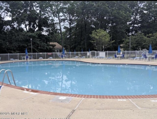 62 Woodshill Dr S, Lakewood, NJ 08701 - community pool with view of scattered trees and a patio