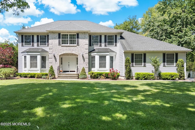 21 Tanglewood Pl, Monroe, NJ 08831 - view of front facade with a front yard, a shingled roof, and brick siding